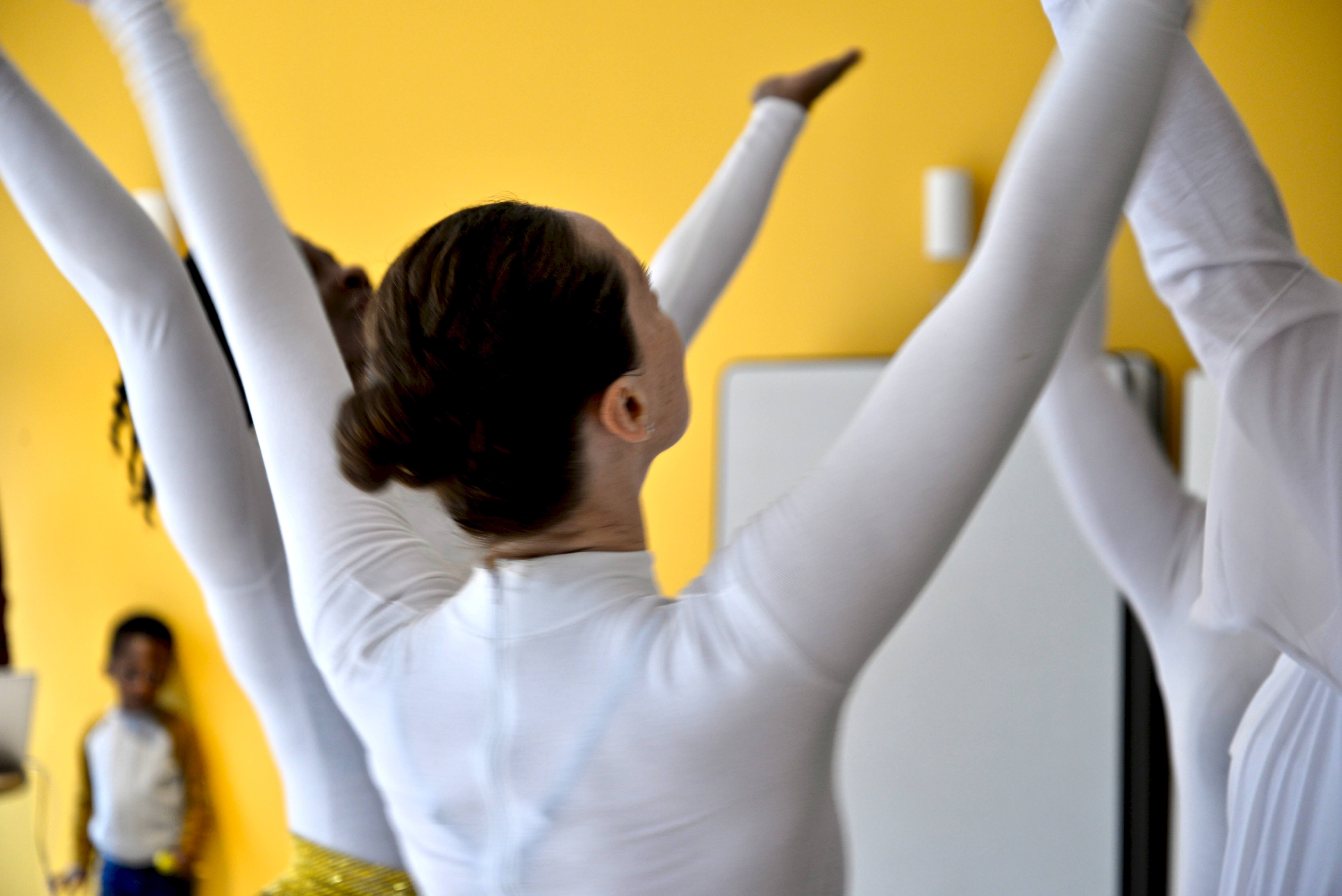 Femmes en blanc qui danse les mains levées